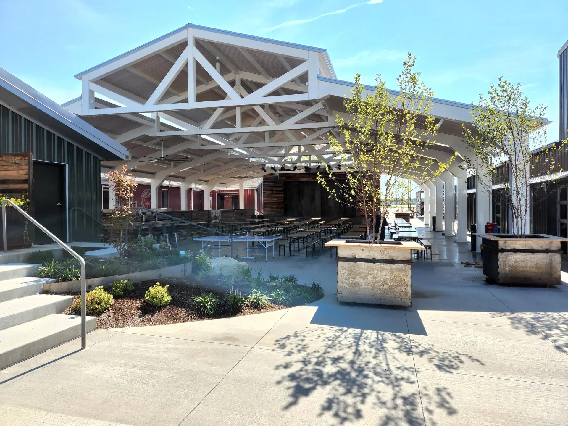 Modern outdoor entertainment venue with timber-frame pavilion and landscaped seating areas